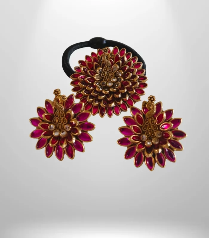 A hair clip with a leaf design and pink stones.